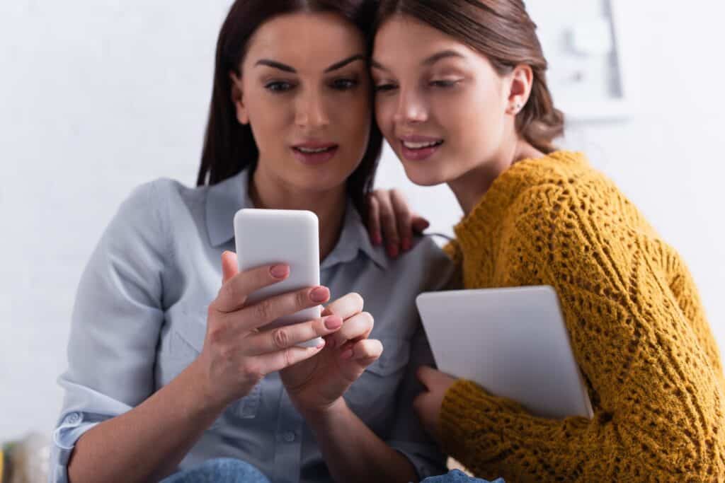 mom and teen looking at smartphone